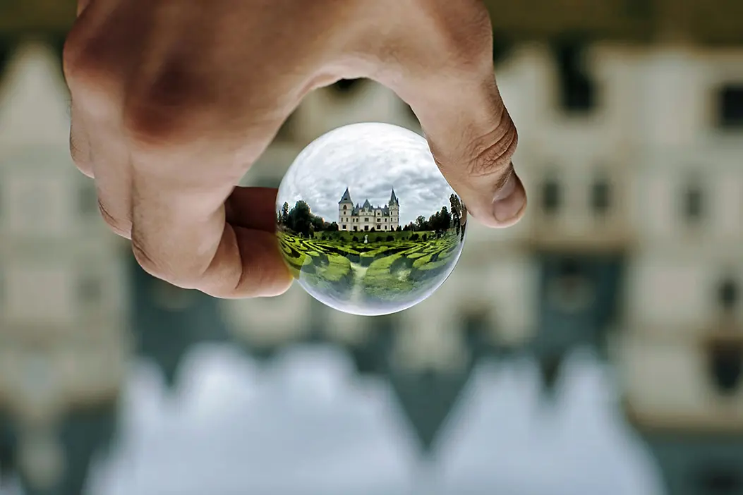 Symbolbild für Einzeltherapie: eine Hand hält eine Glaskugel, die alles auf dem Kopf darstellt
